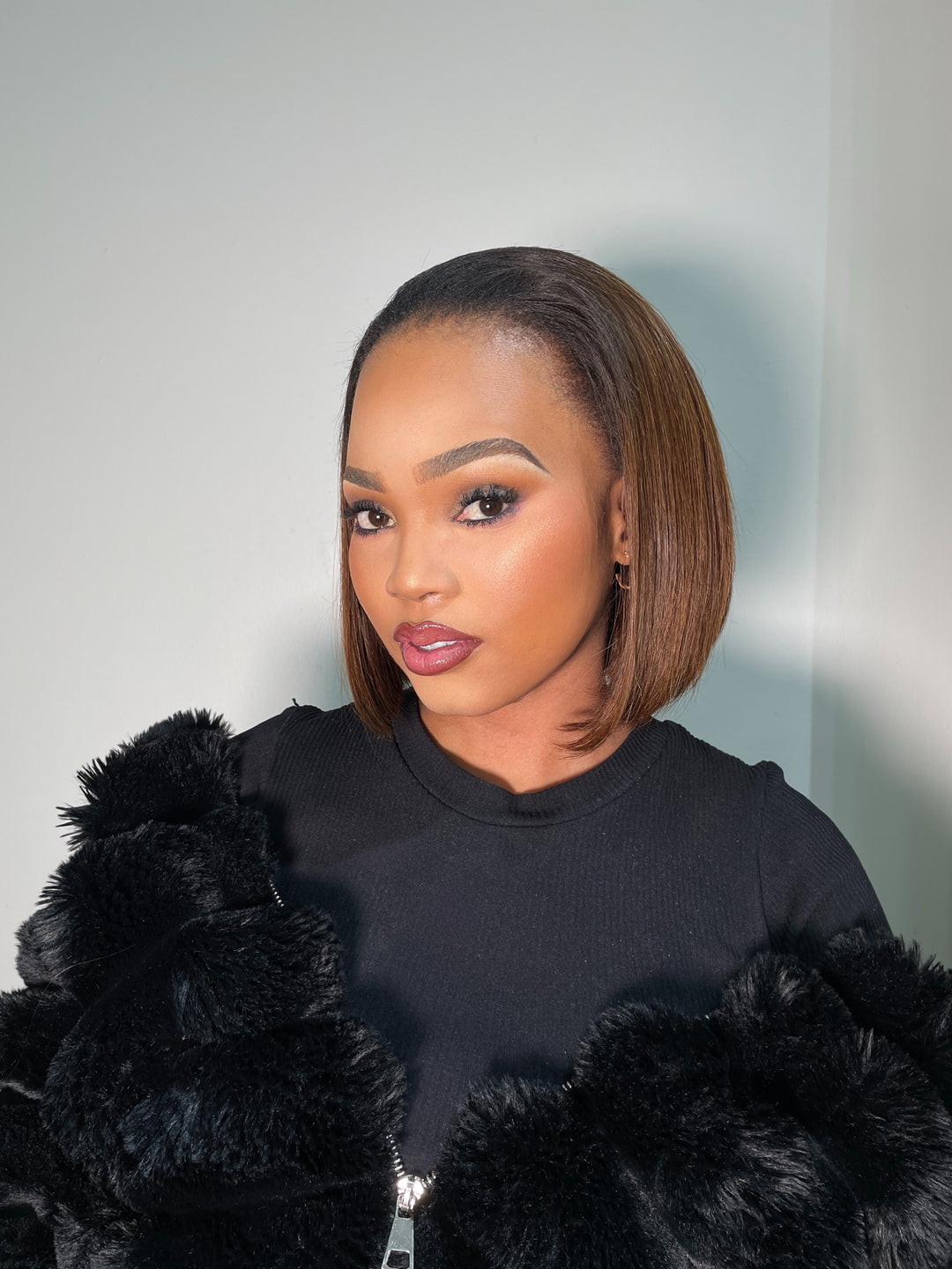 A 10-inch silky straight Peruvian half wig featuring a smooth, thick texture that grazes just above the shoulders. The wig is styled as a sleek bob with a tapered, blunt cut and is blended naturally with a small section of leave-out hair at the crown